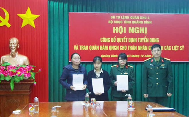 Đại tá Lê Văn Vỹ - Chỉ huy trưởng Bộ Chỉ huy quân sự tỉnh Quảng Bình trao quyết định tuyển dụng quân nhân chuyên nghiệp cho 3 thân nhân liệt sĩ - ảnh Lan Anh