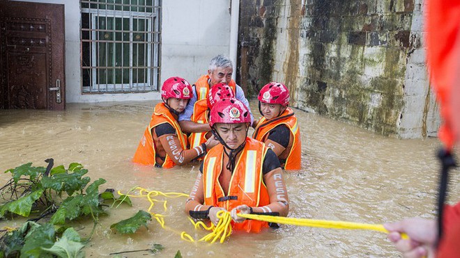 Lũ lụt dâng cao, người dân chèo thuyền đi lại trên phố - Ảnh 8.