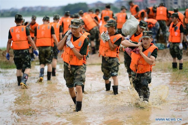 Lũ lụt dâng cao, người dân chèo thuyền đi lại trên phố - Ảnh 9.