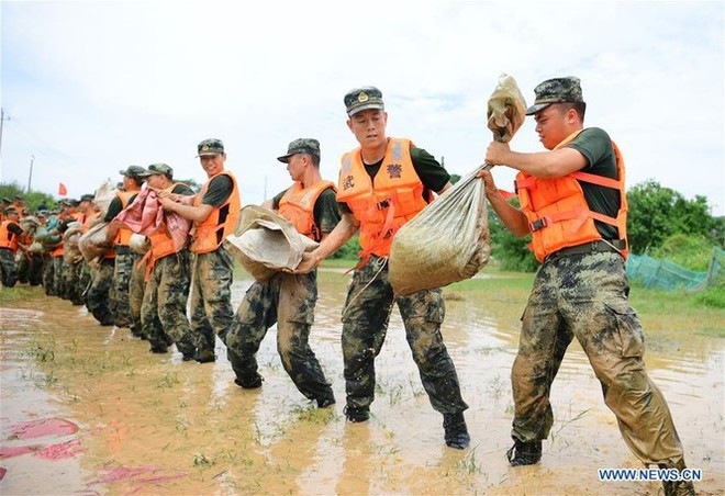 Lũ lụt dâng cao, người dân chèo thuyền đi lại trên phố - Ảnh 10.