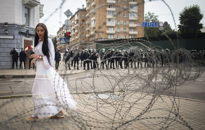 24h qua ảnh: Người phụ nữ quỳ trước hàng rào cảnh sát chống bạo động ở Belarus - Ảnh 10.