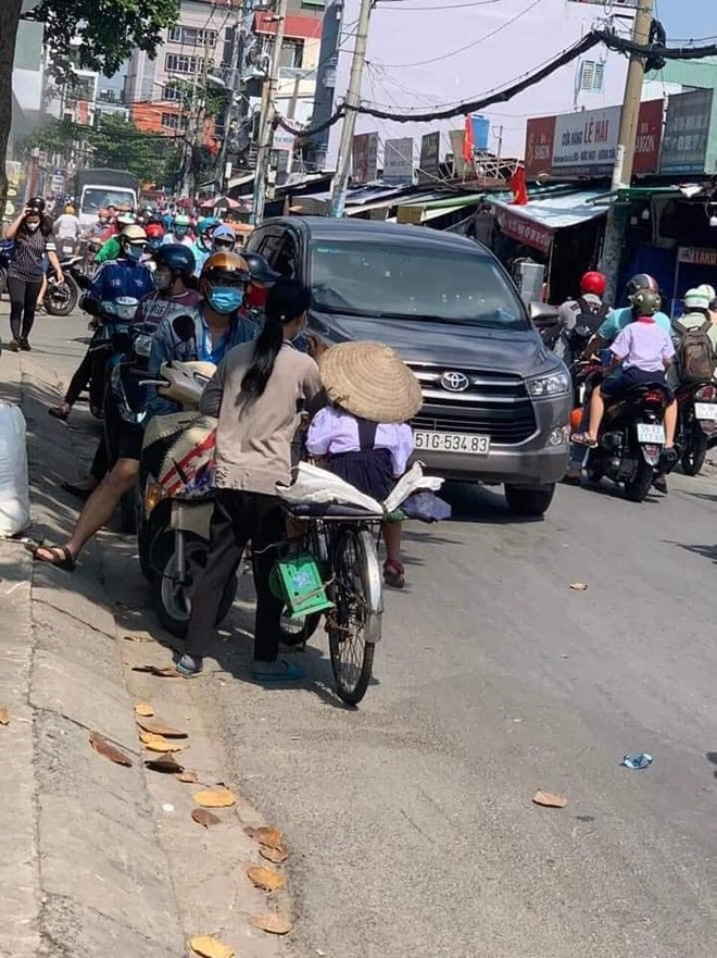 Người mẹ nghèo chở con gái đến trường, thứ cô bé đội trên đầu khiến tất cả lặng người - Ảnh 1.