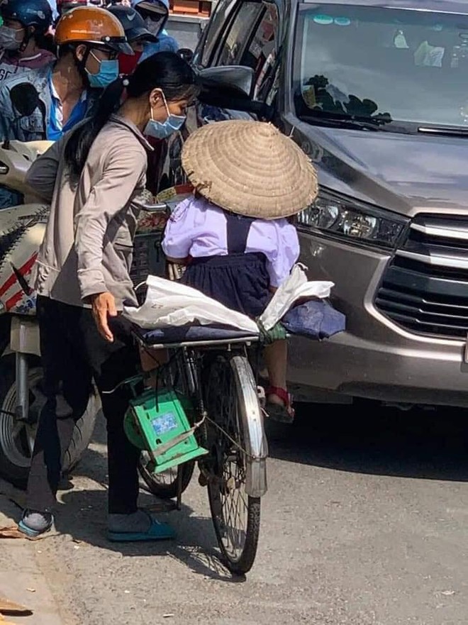 Người mẹ nghèo chở con gái đến trường, thứ cô bé đội trên đầu khiến tất cả lặng người - Ảnh 2.