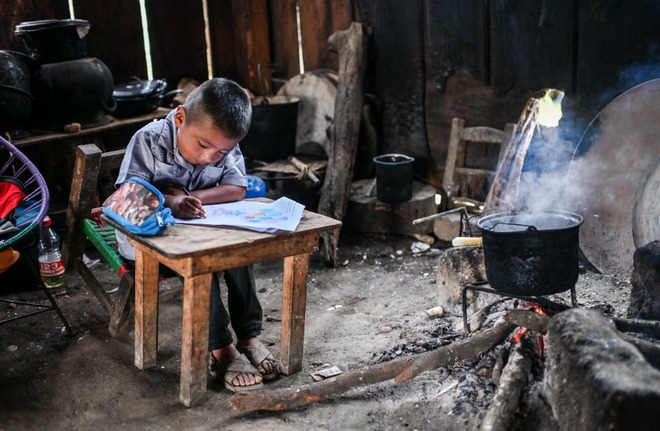 24h qua ảnh: Cậu bé ngồi học cạnh bếp lửa trong nhà - Ảnh 3.