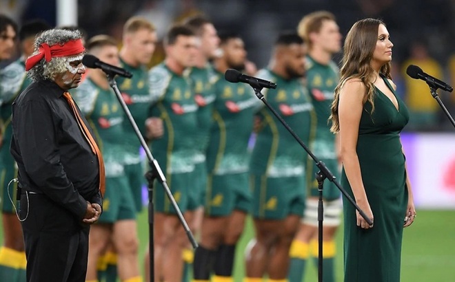 Nữ ca sĩ Olivia Fox người Wiradjuri bản địa hát quốc ca Australia bằng tiếng Eora trong một trận đấu bóng bầu dục. Ảnh AAP