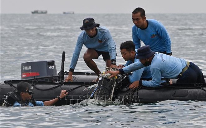 Thợ lặn thuộc các lực lượng hải quân tìm kiếm các mảnh vỡ chiếc máy bay gặp nạn tại vùng biển gần đảo Lancang, Indonesia, ngày 10/1/2021. Ảnh: AFP/TTXVN