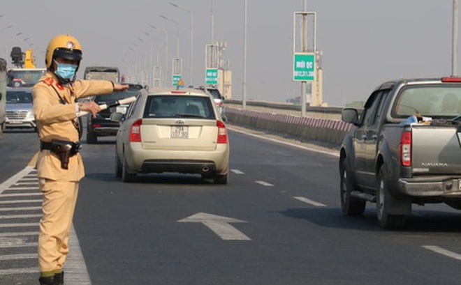 CSGT đang phối hợp phân luồng giao thông để ngăn phương tiện quay đầu trên cầu Thăng Long. Ảnh: Nhật Tân