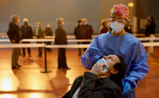 Một nhân viên y tế đang lấy mẫu xét nghiệm Covid-19 cho một người đàn ông ở Tây Ban Nha. Ảnh: Reuters