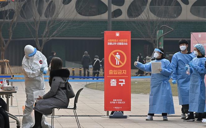 Nhân viên y tế lấy mẫu xét nghiệm COVID-19 tại Seoul, Hàn Quốc. Ảnh: AFP/TTXVN