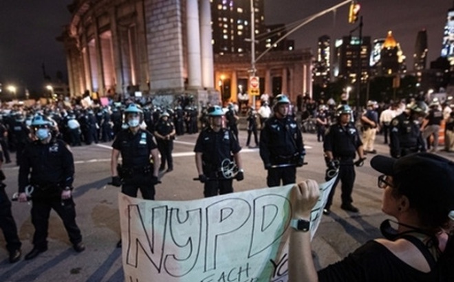 Người biểu tình đối mặt lực lượng an ninh ở New York trong thời gian áp lệnh giới nghiêm tối 2/6. Ảnh: Reuters.