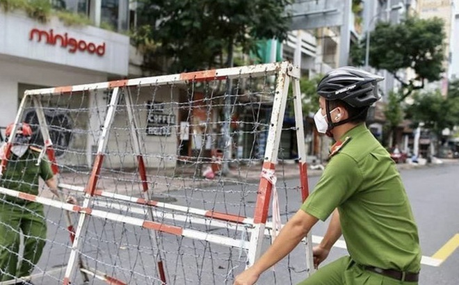 Các lực lượng tháo dỡ rào chắn trên đường Nguyễn Thái Học (Quận 1, TP Hồ Chí Minh). Ảnh: TTXVN