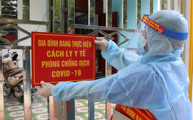 Thành viên tổ Covid-19 cộng đồng thực hiện treo biển cách ly tại gia đình ở TP Hạ Long, Quảng Ninh.