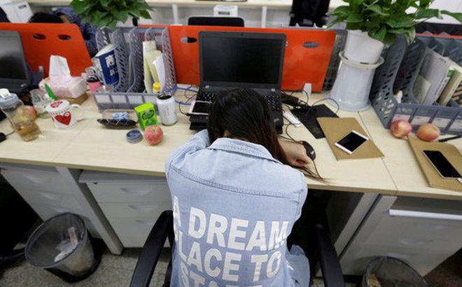 Một nhân viên chợp mắt trên ghế sau bữa trưa ở Bắc Kinh - Trung Quốc. Ảnh: Reuters
