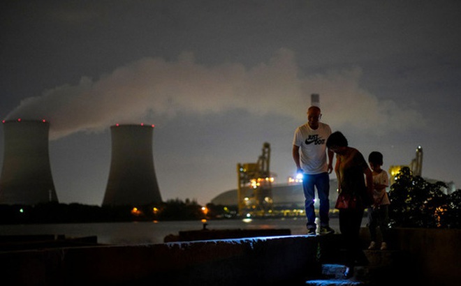 Người dân đi bộ bên sông Hoàng Phố gần một nhà máy nhiệt điện ở TP Thượng Hải, Trung Quốc hôm 14-10. Ảnh: REUTERS