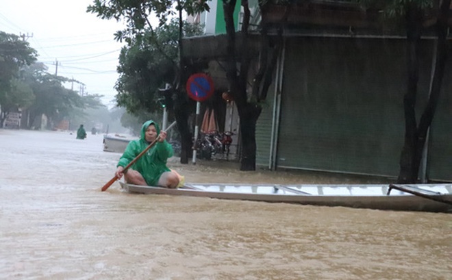 Nhiều người dân ở thị trấn Kiến Giang phải dùng thuyền đi lại trên phố do mưa lũ. Ảnh: HOÀNG PHÚC