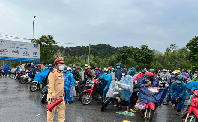 Lực lượng CSGT Công an tỉnh Thanh Hóa hỗ trợ người dân về từ các tỉnh phía Nam tại chốt Khe nước lạnh ở thị xã Nghi Sơn