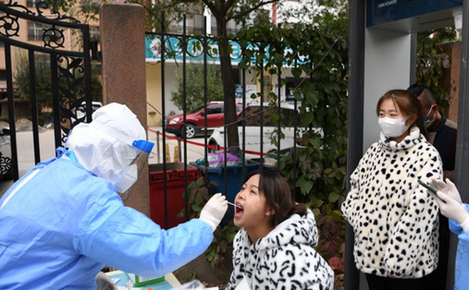 Nhân viên y tế lấy mẫu xét nghiệm người dân tại TP Lan Châu, tỉnh Cam Túc - Trung Quốc hôm 20-10. Ảnh: Reuters