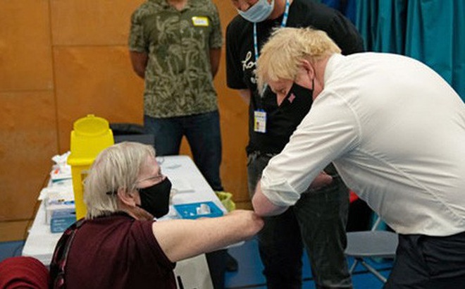 Thủ tướng Anh Boris Johnson giao lưu với cụ Nitza Sarner, 88 tuổi, trong khi cụ chờ được tiêm tăng cường ở thủ đô London hôm 22-10 Ảnh: REUTERS