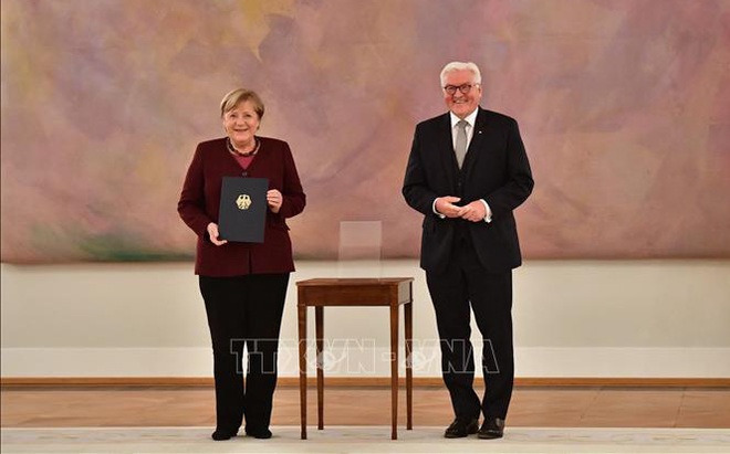 Tổng thống Đức Frank-Walter Steinmeier (phải) sau khi trao quyết định kết thúc nhiệm kỳ công tác cho Thủ tướng Angela Merkel (trái) tại Cung điện Bellevue ở Berlin ngày 26/10/2021. Ảnh: AFP/TTXVN