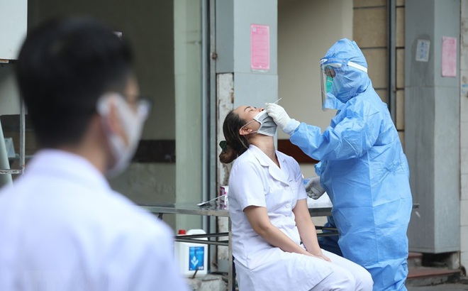 Nhân viên y tế lấy mẫu cho một số nhân viên cửa hàng thuốc ở phố Phủ Doãn.