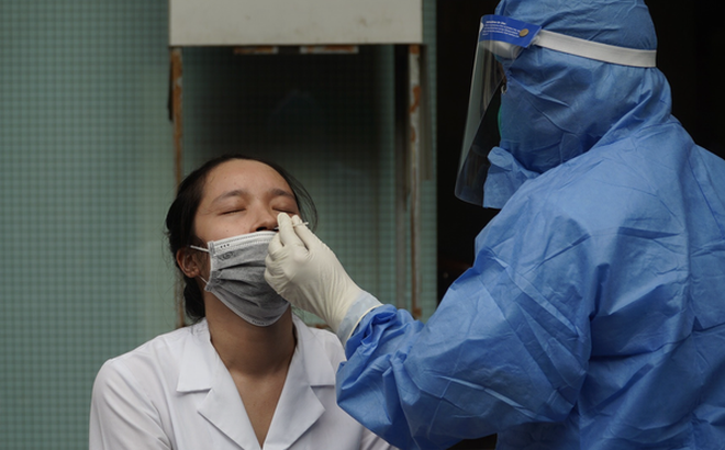 Nhân viên y tế lấy mẫu cho nhân viên cửa hàng thuốc gần khu vực BV Việt Đức.