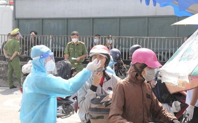 Tổ chức test nhanh COVID-19 cho người dân trước khi qua chốt kiểm soát để về quê tại khu vực Thị trấn Tân Túc, huyện Bình Chánh, Thành phố Hồ Chí Minh. (Ảnh: TTXVN phát)