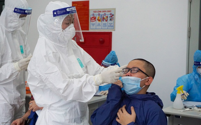 Nhân viên y tế lấy mẫu cho trẻ em ở Hà Nội.