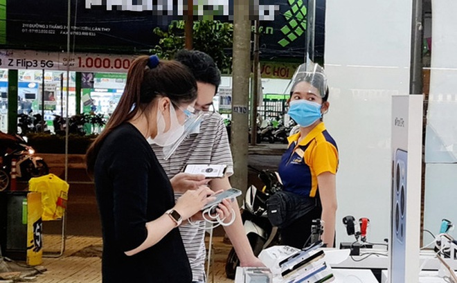 Người dân tuân thủ đeo khẩu trang khi mua hàng trong một cửa hàng điện thoại di động