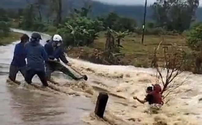 Mọi người hỗ trợ, giải cứu người phụ nữ thoát khỏi dòng nước lũ.