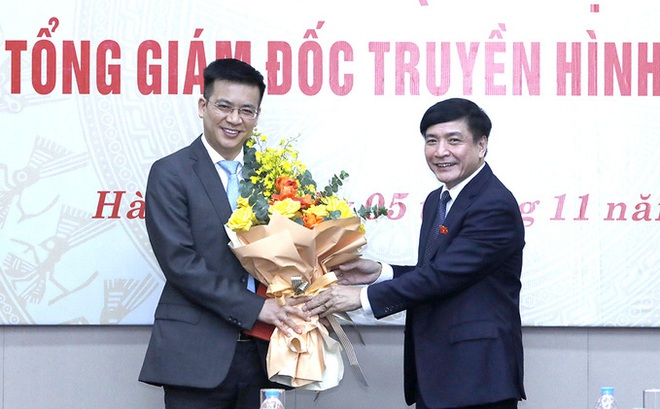 Tổng Thư ký Quốc hội Bùi Văn Cường (bên phải) tặng hoa chúc mừng tân Tổng giám đốc Truyền hình Quốc hội Việt Nam Lê Quang Minh.