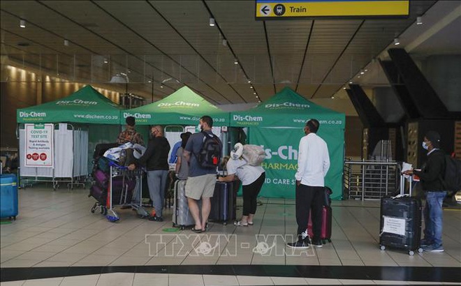 Hành khách xếp hàng chờ xét nghiệm COVID-19 tại sân bay ở Johannesburg, Nam Phi, ngày 27/11. Ảnh: AFP/TTXVN