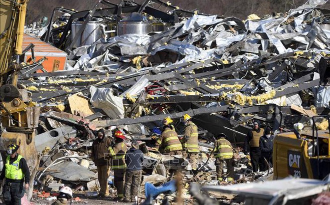 Lực lượng cứu trợ khẩn cấp tìm kiếm các nạn nhân và khắc phục hậu quả tại hiện trường đổ nát do bão và lốc xoáy tàn phá ở Mayfield, bang Kentucky, Mỹ ngày 11/12/2021. Ảnh: AFP/TTXVN