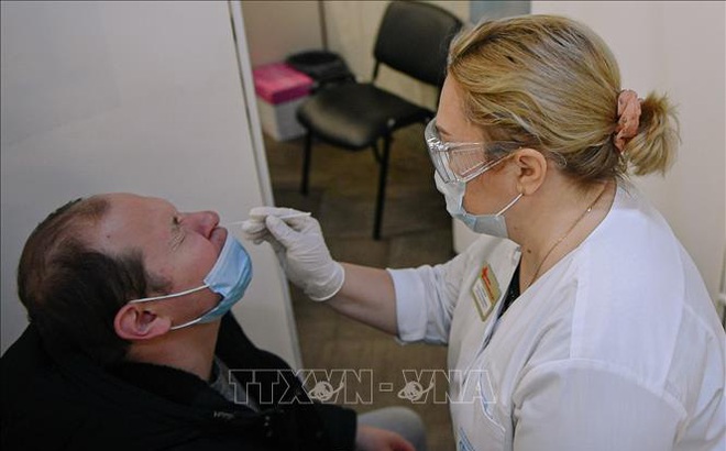 Nhân viên y tế lấy mẫu xét nghiệm COVID-19 cho người dân tại Moskva, Nga. Ảnh: THX/TTXVN