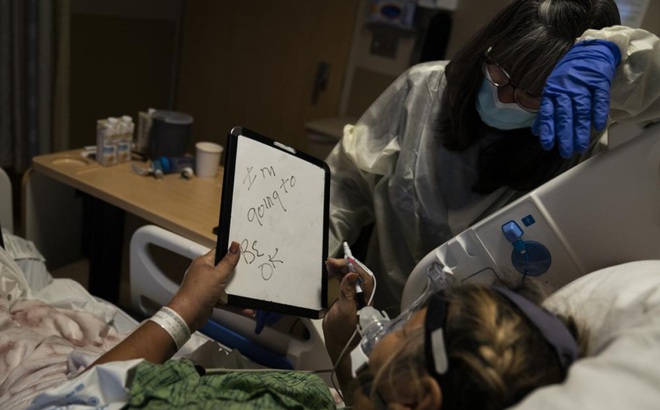 Mary Lou Samora, bệnh nhân Covid-19 71 tuổi, viết dòng chữ “Tôi sẽ ổn thôi” khi một người bạn tới thăm tại Trung tâm y tế Providence Holy Cross ngay 17/12. Ảnh: AP