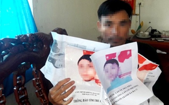 Ông Phan Hữu L. bên những tấm ảnh của con trai bị nhóm đòi nợ in, dán khắp nơi trên địa bàn xã để khủng bố tinh thần.