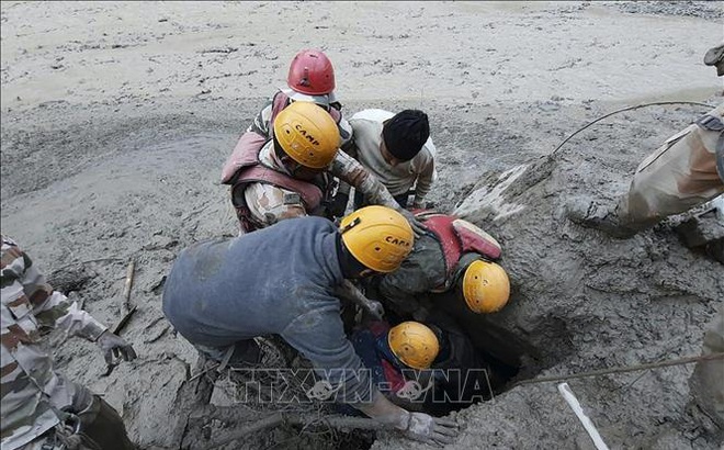 Lực lượng cứu hộ tìm kiếm nạn nhân tại khu vực bị ảnh hưởng bởi trận lũ quét ở bang Uttarakhand, Ấn Độ do vỡ sông băng trên dãy Himalaya, ngày 7/2/2021. Ảnh: AFP/TTXVN