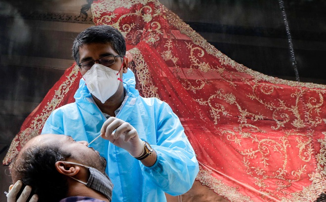 Một nhân viên y tế lấy mẫu xét nghiệm COVID-19 cho người dân tại Mumbai. Ảnh: AP