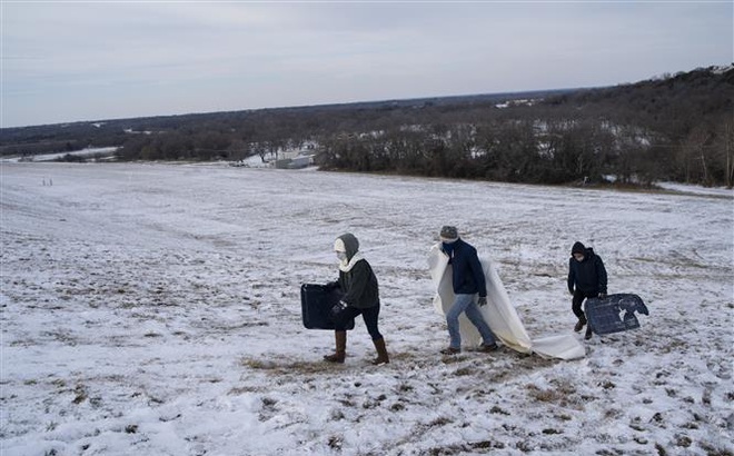Người dân di chuyển trên đồi phủ đầy tuyết trắng ở Waco, bang Texas, Mỹ ngày 18/2. Ảnh: AFP/TTXVN