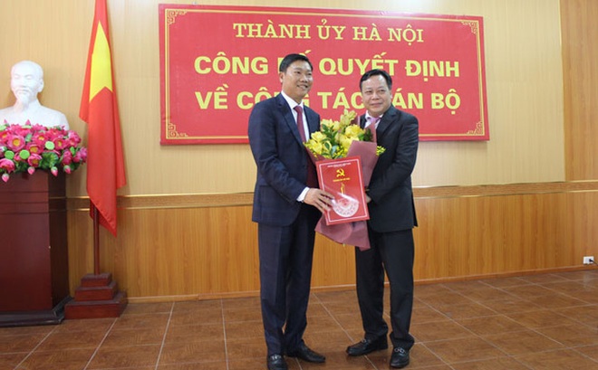 Ông Nguyễn Văn Phong, Phó Bí thư Thành ủy Hà Nội, trao quyết định và tặng hoa chúc mừng tân Giám đốc Sở Kế hoạch và Đầu tư Hà Nội - Ảnh: ĐH