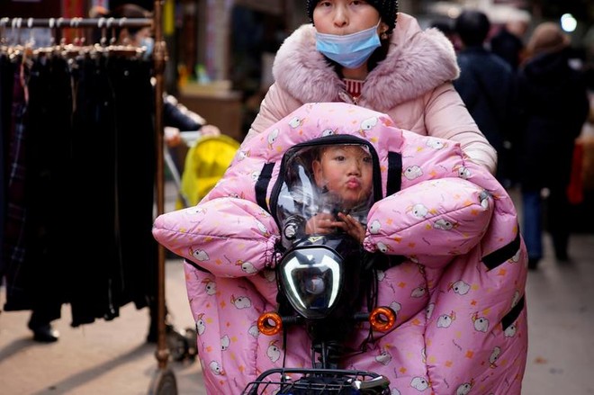 24h qua ảnh: Người mẹ chở con đi trong thời tiết giá lạnh ở TQ - Ảnh 2.