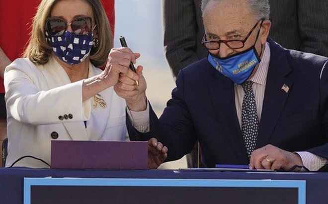 Chủ tịch Hạ viện Nancy Pelosi (trái) và Lãnh đạo Phe đa số Thượng viện Chuck Schumer vui mừng sau khi gói cứu trợ được thông qua hôm 10-3. Ảnh: AP