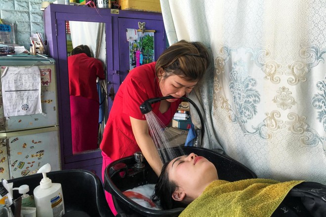 Người phụ nữ Việt mất tay vẫn thành thợ cắt tóc lên báo nước ngoài - Ảnh 4.