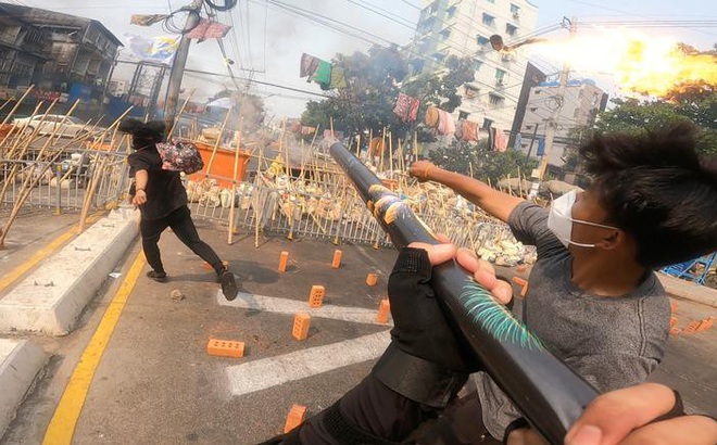 Người biểu tình ném bom xăng ở Yangon. Ảnh: Reuters