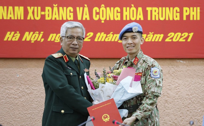 Thượng tướng Nguyễn Chí Vịnh, Thứ trưởng Quốc phòng, trao quyết định của Chủ tịch nước cho trung tá Trần Đức Hưởng sáng 12-3. Ảnh: TTXVN