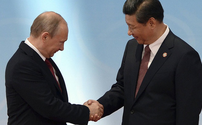 Tổng thống Nga Vladimir Putin (trái) bắt tay Chủ tịch Trung Quốc Tập Cận Bình. Ảnh: The New York Times