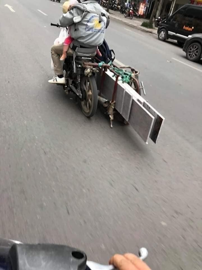 Người đàn ông chở đồ cồng kềnh trên phố, nhìn kĩ đứa bé anh ôm trước ngực ai cũng thấy thương - Ảnh 1.