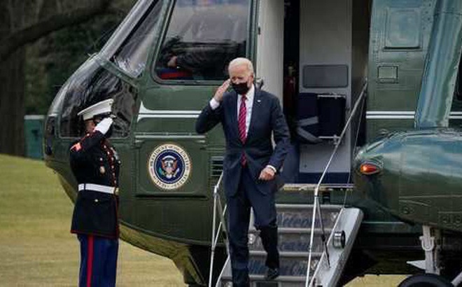 Tổng thống Joe Biden giơ tay chào khi ông rời trực thăng chuyên cơ Marine One trên bãi cỏ phía nam của Nhà Trắng.