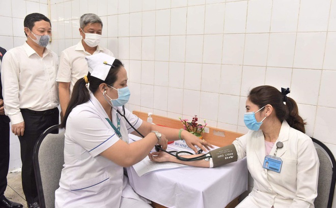 Thứ trưởng Bộ Y tế Nguyễn Trường Sơn (người đứng bên phải) giám sát việc tiêm chủng tại Bệnh viện Bệnh Nhiệt đới TP HCM ngày 8/3.
