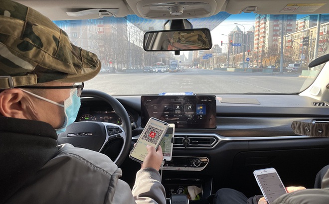 Khách đi xe taxi tại thủ đô Bắc Kinh thực hiện quy định quét mã QR y tế. Ảnh: GT