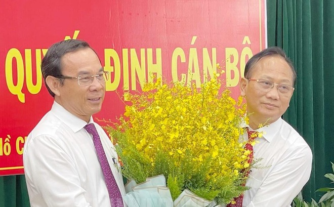 Bí thư Thành ủy TPHCM Nguyễn Văn Nên tặng hoa chúc mừng ông Trần Văn Nam (phải). Ảnh: Thành ủy TPHCM